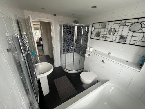 y baño con ducha, aseo y lavamanos. en Wilford Charm: Spacious 3BR Gem!, en Nottingham