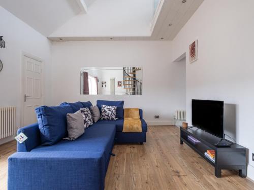 a living room with a blue couch and a flat screen tv at Contractor-Friendly 2Bed Nr Sunderland Hospital in Sunderland