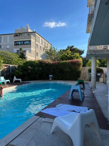 - une piscine avec banc à côté d'un bâtiment dans l'établissement Studio Marseille Prado Plages, à Marseille