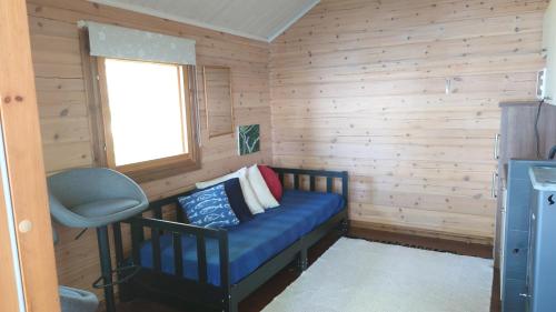 Habitación pequeña con sofá azul y ventana en Hanhi Linna en Taivalkoski