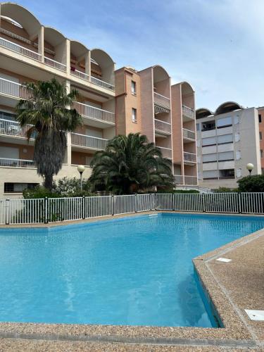 une grande piscine bleue devant un immeuble dans l'établissement Superbe 2pièces, proche plage de Grazel, et port, à Gruissan