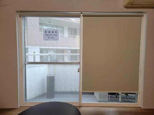 a sliding glass door with a window in a room at P-STAY広島平和公園withペット 401号室 in Hiroshima