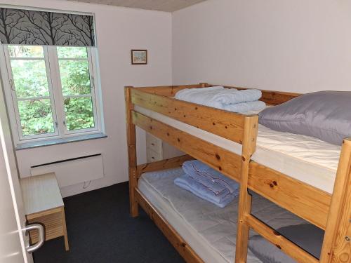 a bedroom with a bunk bed and a window at Kaptajnen at Gammel Rye in Ry