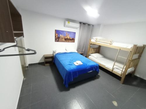 1 dormitorio con 1 cama azul y literas en CASA HOTEL YEMI en Barranquilla