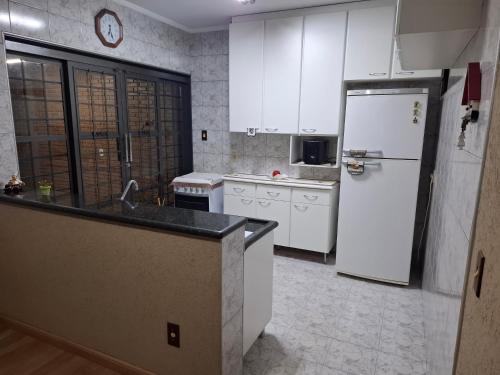 a kitchen with white appliances and a white refrigerator at Casa completa com área de lazer próxima ao centro shopping e principais vias de acesso!! in Araraquara