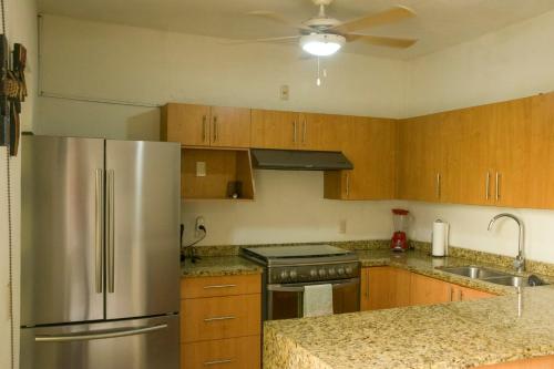 a kitchen with wooden cabinets and a stainless steel refrigerator at Tropical Getaway in Flamingos near Beach in Bucerías