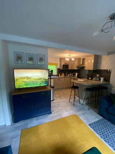 a living room with a tv and a kitchen at Betty’s Hideaway in Caernarfon