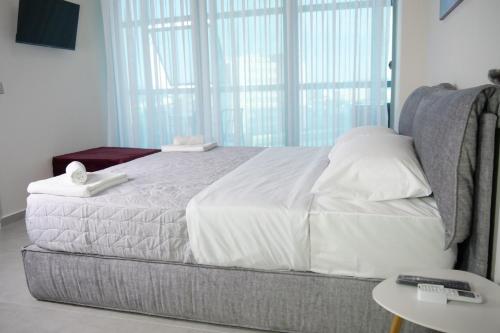 a bedroom with a large bed with a window at STAY-FIVE rooms & apartments in Shkodër