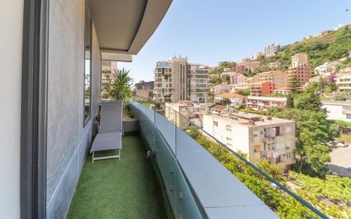 a balcony with a chair and a view of a city at Amare Luxury Apartments in Budva