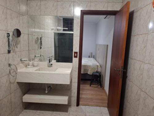 uma casa de banho com um lavatório e um espelho grande em Casa/Sobrado em Araraquara-SP em Araraquara