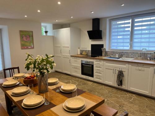 une cuisine avec une table en bois et des plaques de cuisson. dans l'établissement Gîte de la Petite Mauve, à Baule