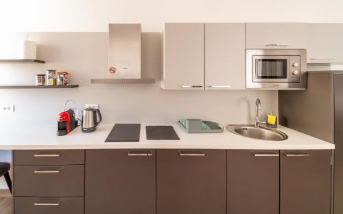 a kitchen with a sink and a microwave at Amare Luxury Apartments in Budva