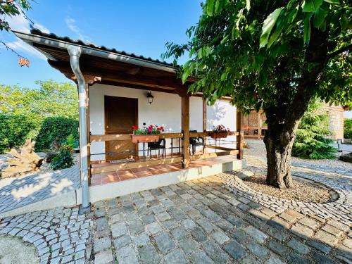 a small house with a table and a tree at Elements Lednice in Lednice