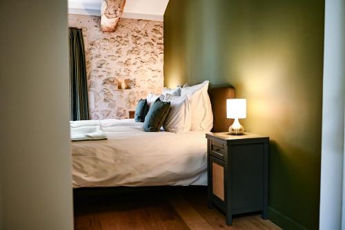 a bedroom with a bed and a night stand with a lamp at Le Mas Gascon - Maison de vacances 4 étoiles avec piscine et vue proche de Lectoure in Marsolan