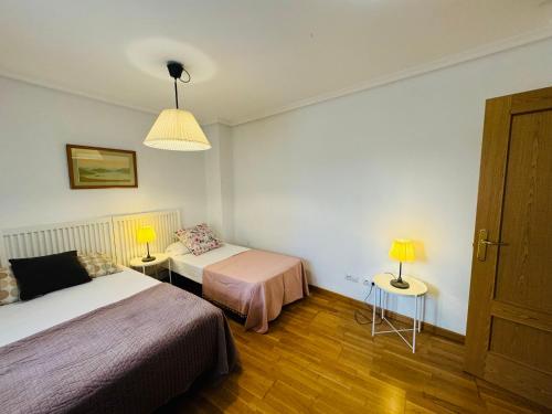 a hotel room with two beds and a lamp at Palacio de Los Luna in Zaragoza
