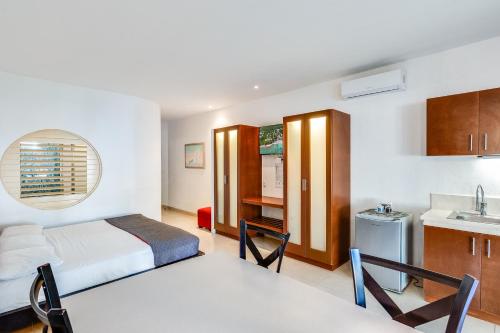 1 dormitorio con 1 cama y 1 mesa en una habitación en Maia Suites Cozumel en Cozumel