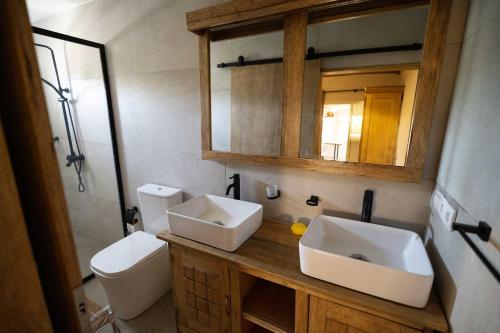 a bathroom with a sink and a toilet and a mirror at La Teranga Apartament in Toubakouta
