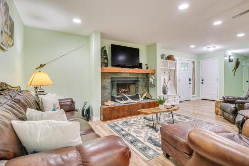 a living room with leather furniture and a fireplace at Cotter Home with Deck about 1 Mi to Big Spring Park! in Cotter