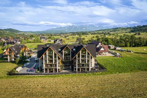 an aerial view of a house in a green field at Góralski Resort Pool & SPA in Białka Tatrzanska