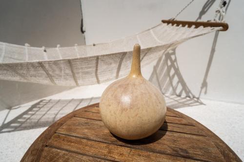 a vase sitting on a table in front of a painting at La Teranga Apartament Parrot in Toubakouta