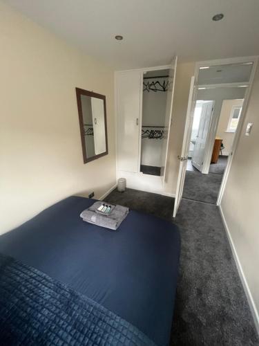 a bedroom with a blue bed and a mirror at Wilford Charm Spacious 3BR Retreat in Nottingham in Nottingham