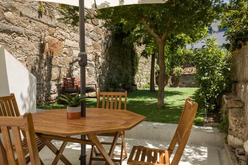a wooden table and chairs on a patio at Almada Charm Suites & Apartments in Porto