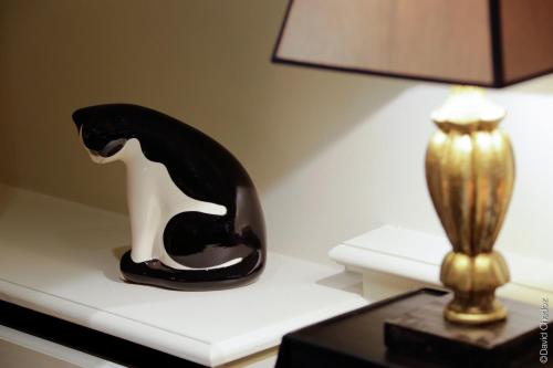 a black and white vase sitting on a table next to a lamp at La Cour Berbisey - Teritoria in Dijon