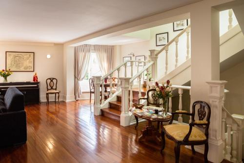 a living room with a staircase and a table and chairs at Old City Guest House in Braga