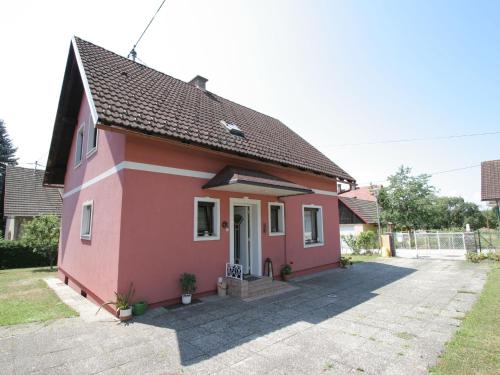 ein kleines rosafarbenes Haus mit einer weißen Tür in der Unterkunft Modern apartment with garden near the Petzen ski area in Eberndorf Carinthia in Eberndorf