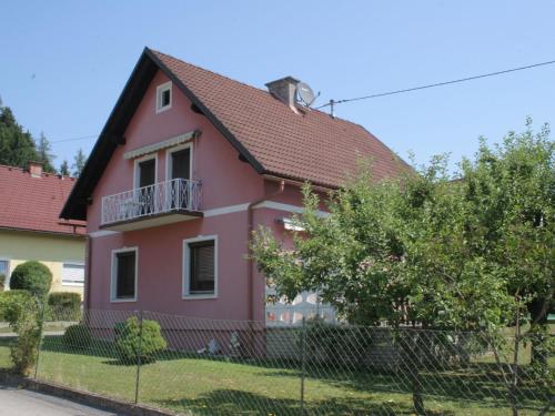 ein rosafarbenes Haus mit Balkon in der Unterkunft Modern apartment with garden near the Petzen ski area in Eberndorf Carinthia in Eberndorf