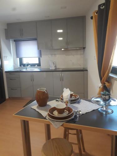 a kitchen with a table with plates and cups on it at Cantinho da Fonte in Calvos