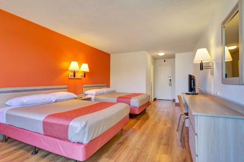 2 letti in una camera d'albergo con pareti arancioni di Motel 6-Belmont, CA - San Francisco - Redwood City a Belmont