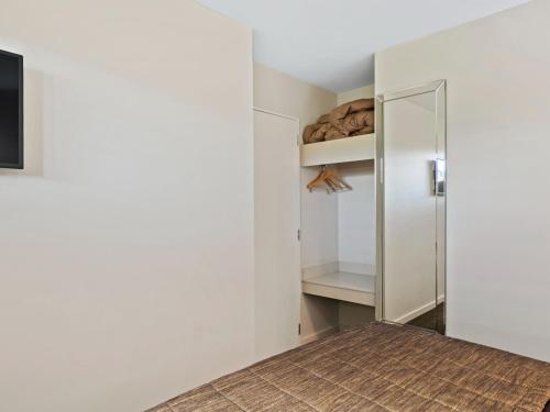 einen begehbaren Kleiderschrank mit weißen Wänden und einem Spiegel in der Unterkunft Clear Ridge Apartments in Hanmer Springs