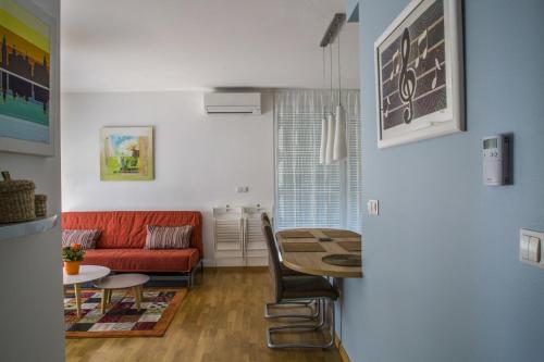 - un salon avec un canapé rouge et une table dans l'établissement Lakeside Jarun Apartment, à Zagreb