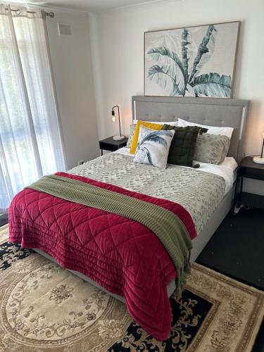 a bedroom with a large bed with a red blanket at Sunshine Seven in Salisbury