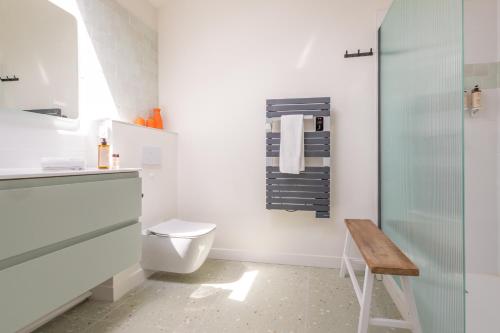 a white bathroom with a toilet and a stool at Le Mas Gascon - Maison de vacances 4 étoiles avec piscine et vue proche de Lectoure in Marsolan