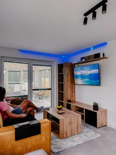 a woman sitting on a couch in a living room at Apartment Fratello in Šoporňa