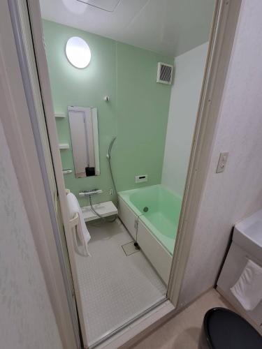 a bathroom with a green tub and a sink at P-STAY広島平和公園withペット 401号室 in Hiroshima