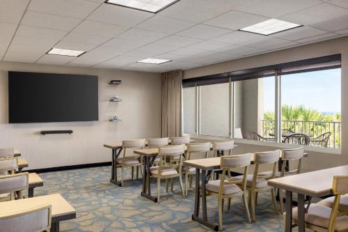 a classroom with tables and chairs and a projection screen at Holiday Inn Resort Jekyll Island by IHG in Jekyll Island