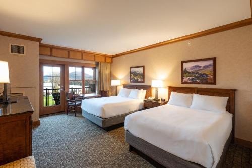 a hotel room with two beds and a desk at Crowne Plaza Lake Placid by IHG in Lake Placid