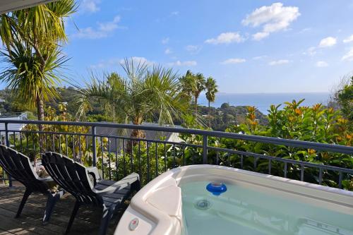 a hot tub on a balcony with two chairs at Palm Beach Perfection SPA Pool Free WIFI in Palm Beach