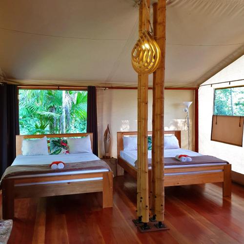 a bedroom with two beds in a tent at Houttuyn Wellness River Resort in Paramaribo