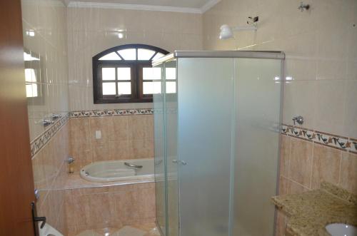 a bathroom with a shower and a bath tub at Chacara otima localizacao in Jarinu