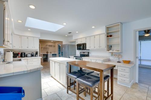 a kitchen with white cabinets and a wooden table at 5 Mi to Busch Gardens Tampa Bay Villa with Pool! in Tampa