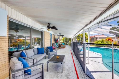 a patio with a couch and a table next to a pool at 5 Mi to Busch Gardens Tampa Bay Villa with Pool! in Tampa