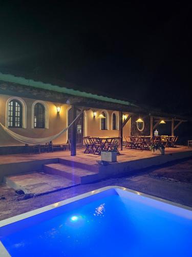 een zwembad voor een gebouw 's nachts bij Pousada Casa Bella in Itaberaba