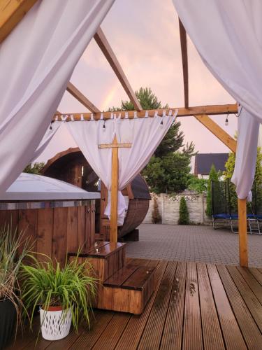 a wooden deck with a cross under a tent at Apartamenty Morski Brzeg - Sauna, Balia in Władysławowo