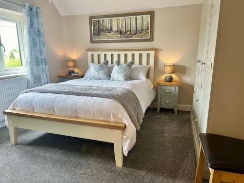 a bedroom with a large bed with two night stands at Lanstone House in Chipping Norton
