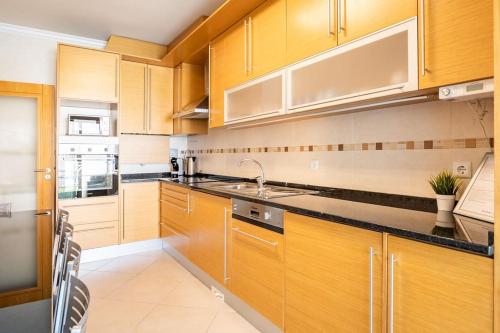 a kitchen with wooden cabinets and a sink at Casa Nazare in Nazaré
