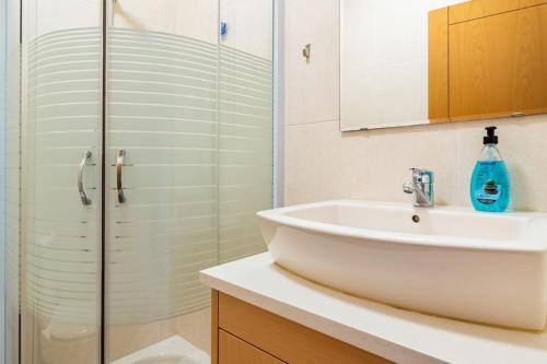 a bathroom with a sink and a glass shower at Casa Nazare in Nazaré